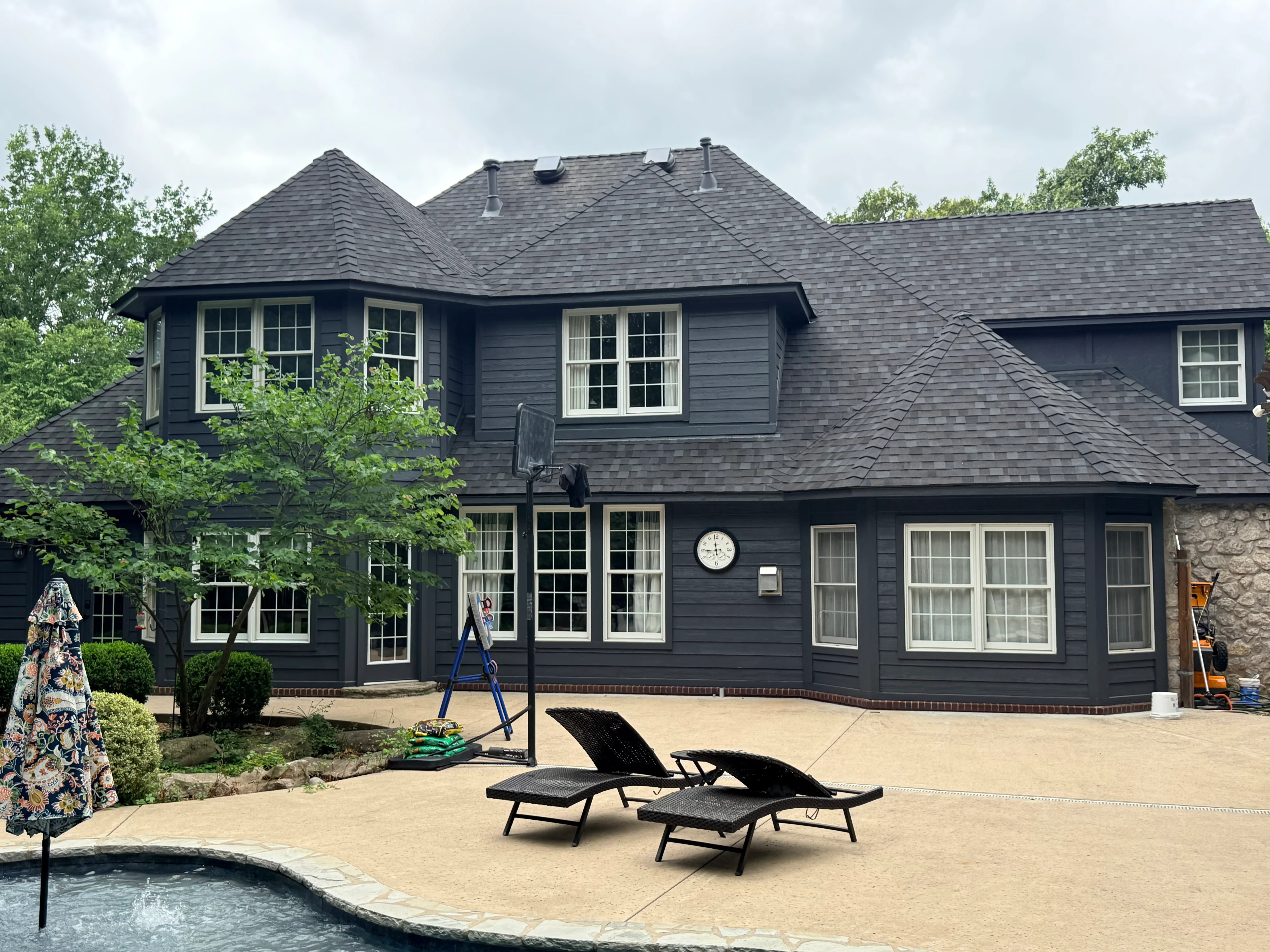 Two-story home with new charcoal gray architectural shingle roof and dark siding