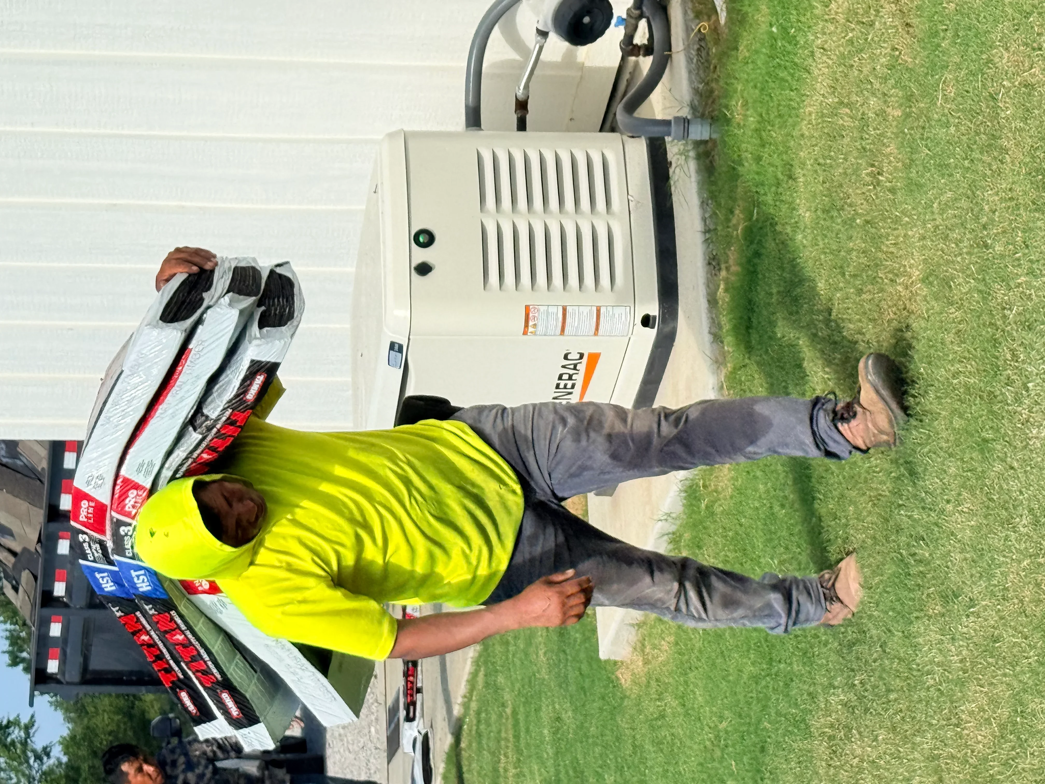 Roofing contractor with lift equipment and bundled roofing materials on residential property