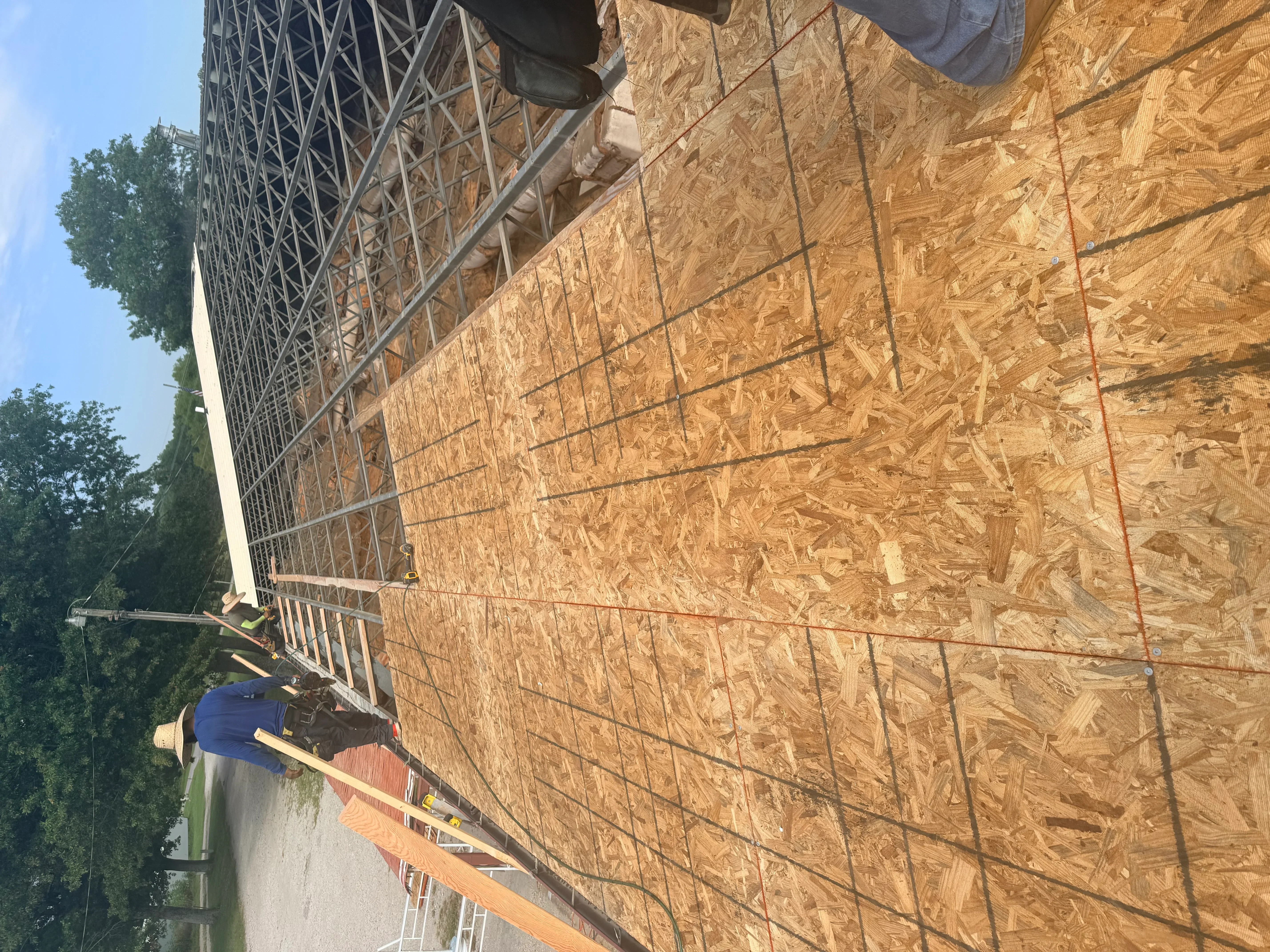 Roof framing with metal trusses and OSB sheathing during construction phase