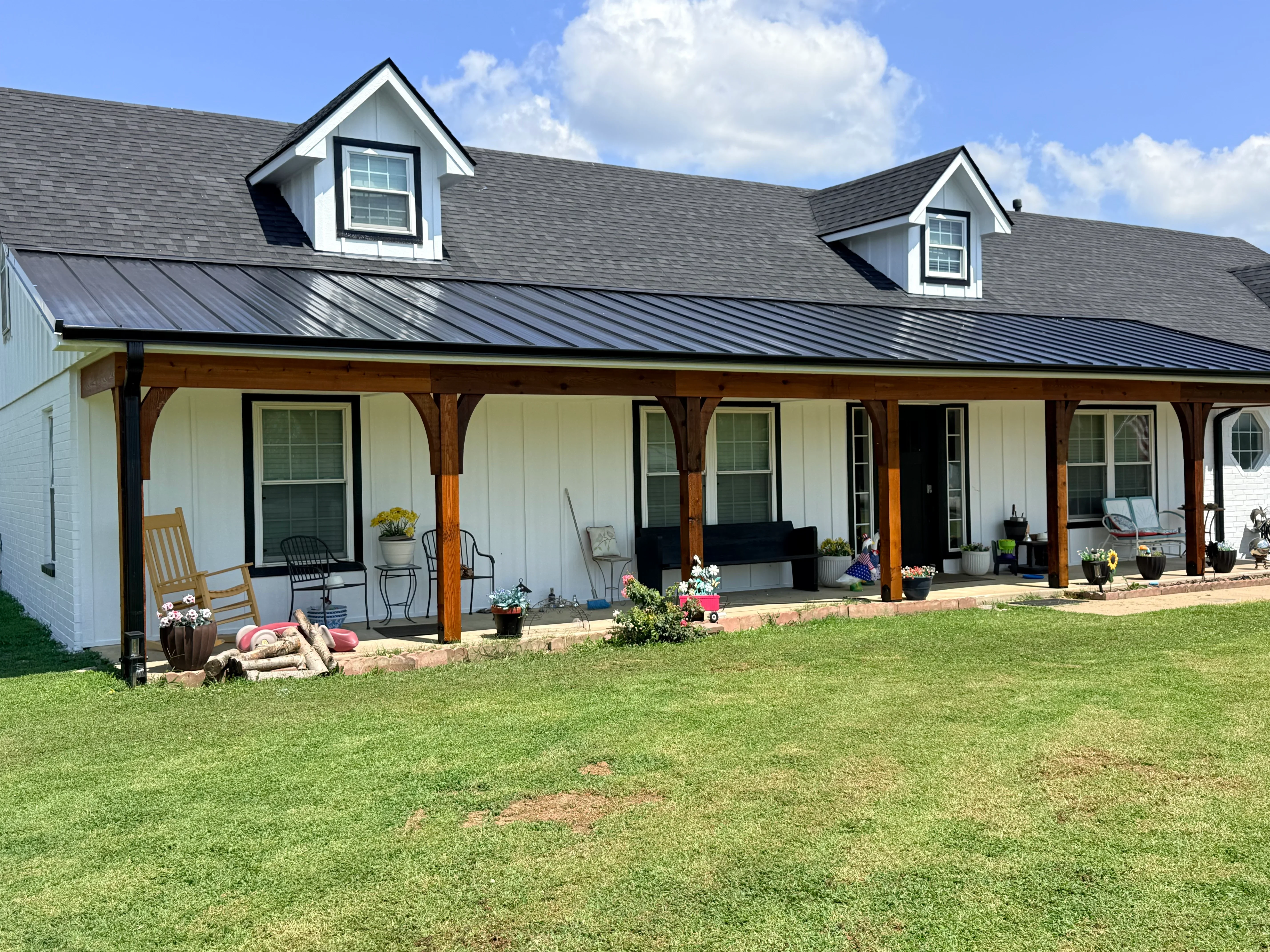 Standing seam metal roof with two dormers, charcoal gray finish on residential home