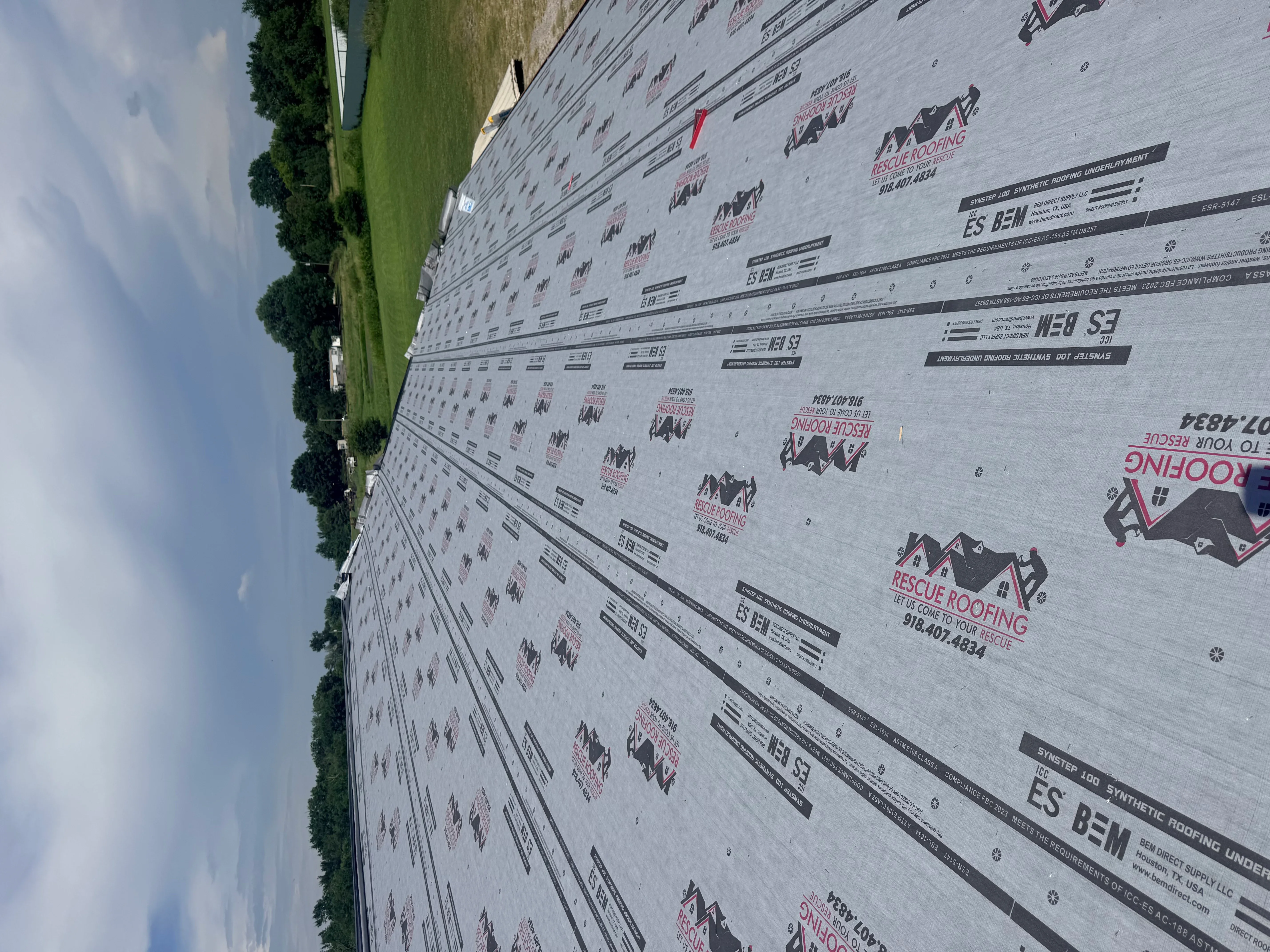 Synthetic roofing underlayment with fasteners and product markings installed on residential roof deck