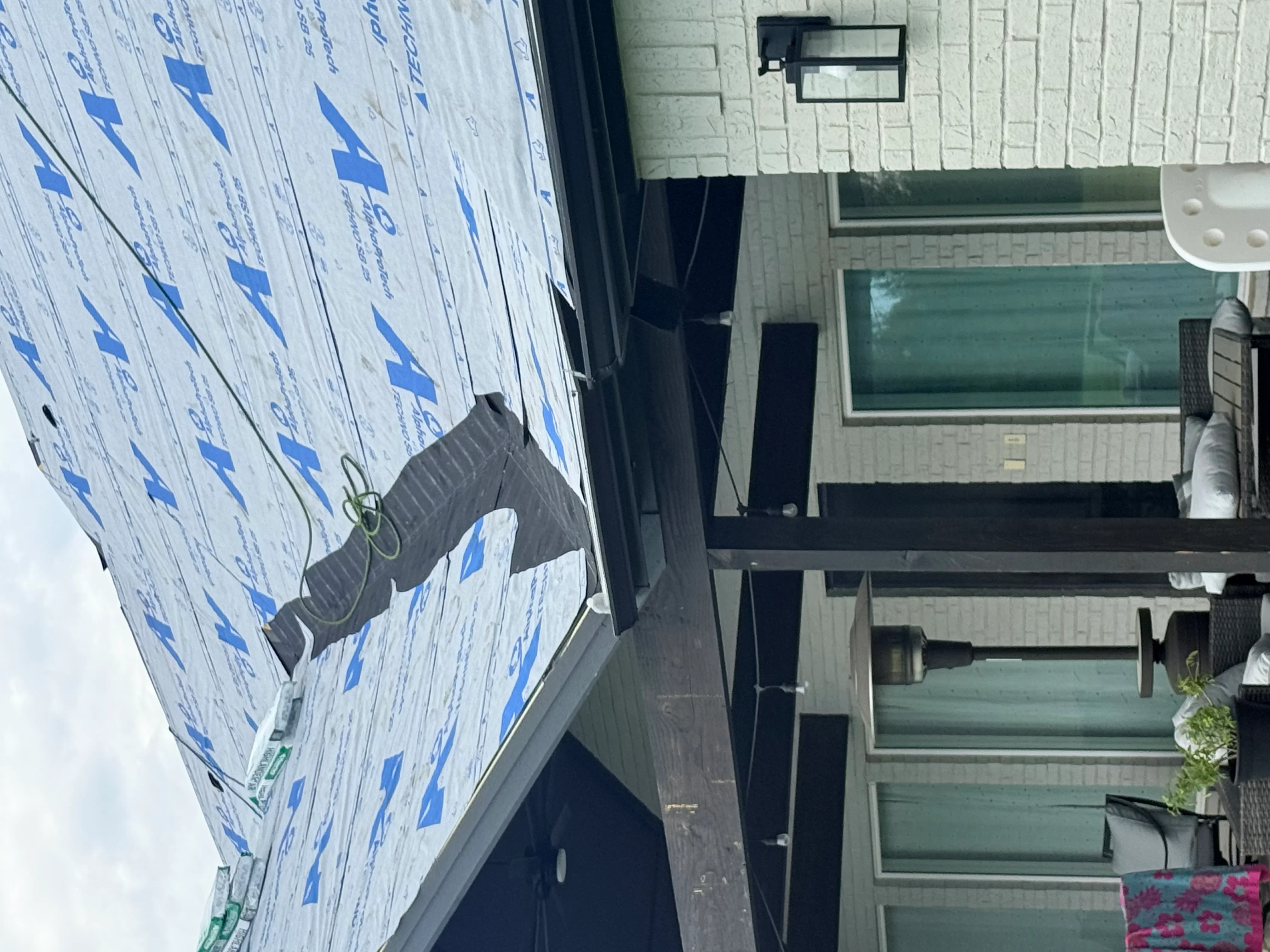 Blue synthetic roofing underlayment installed with fasteners and overlapping seams on residential roof deck