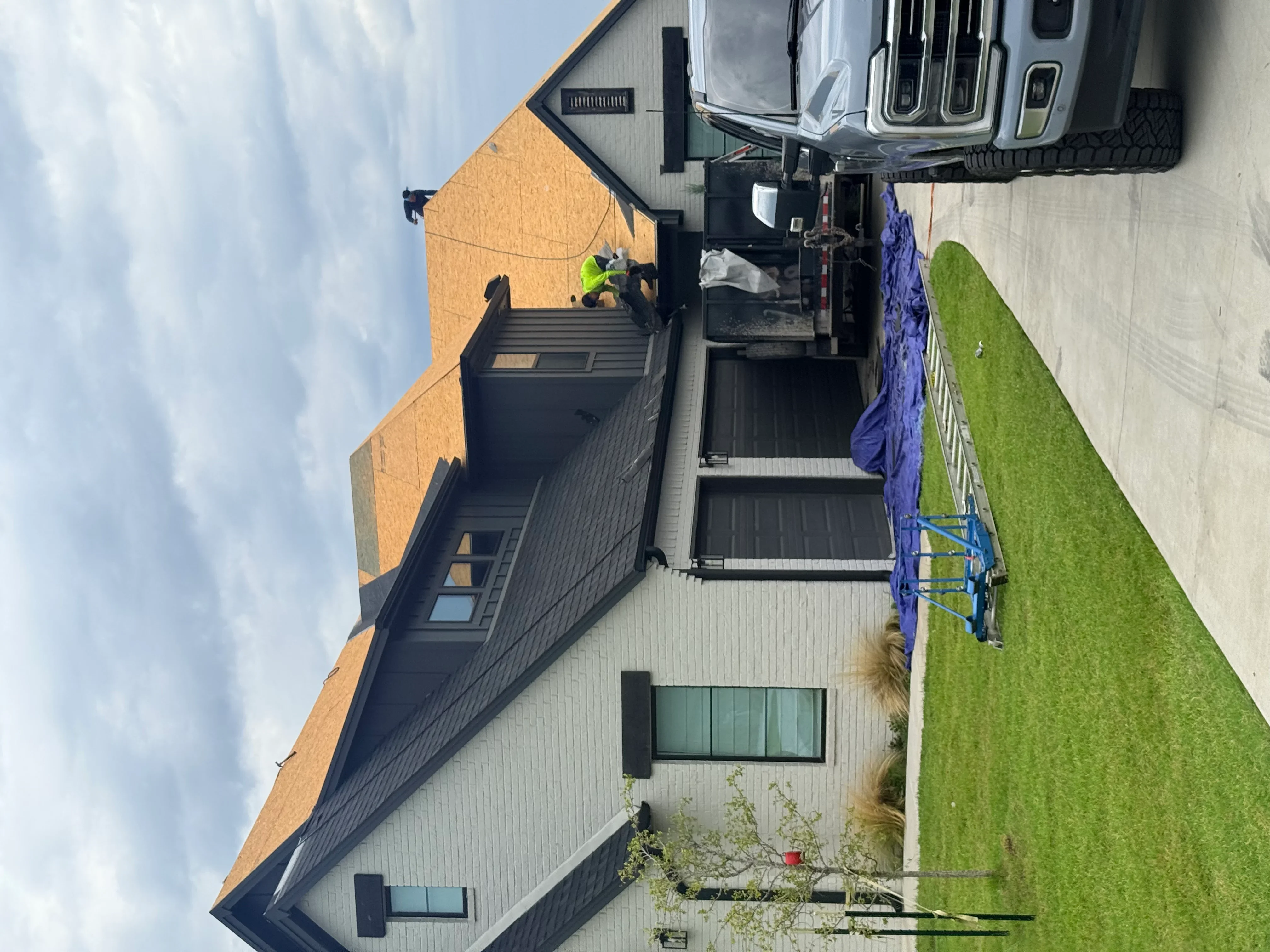 Dark gray asphalt shingle roof installation on residential home with metal flashing and proper ventilation