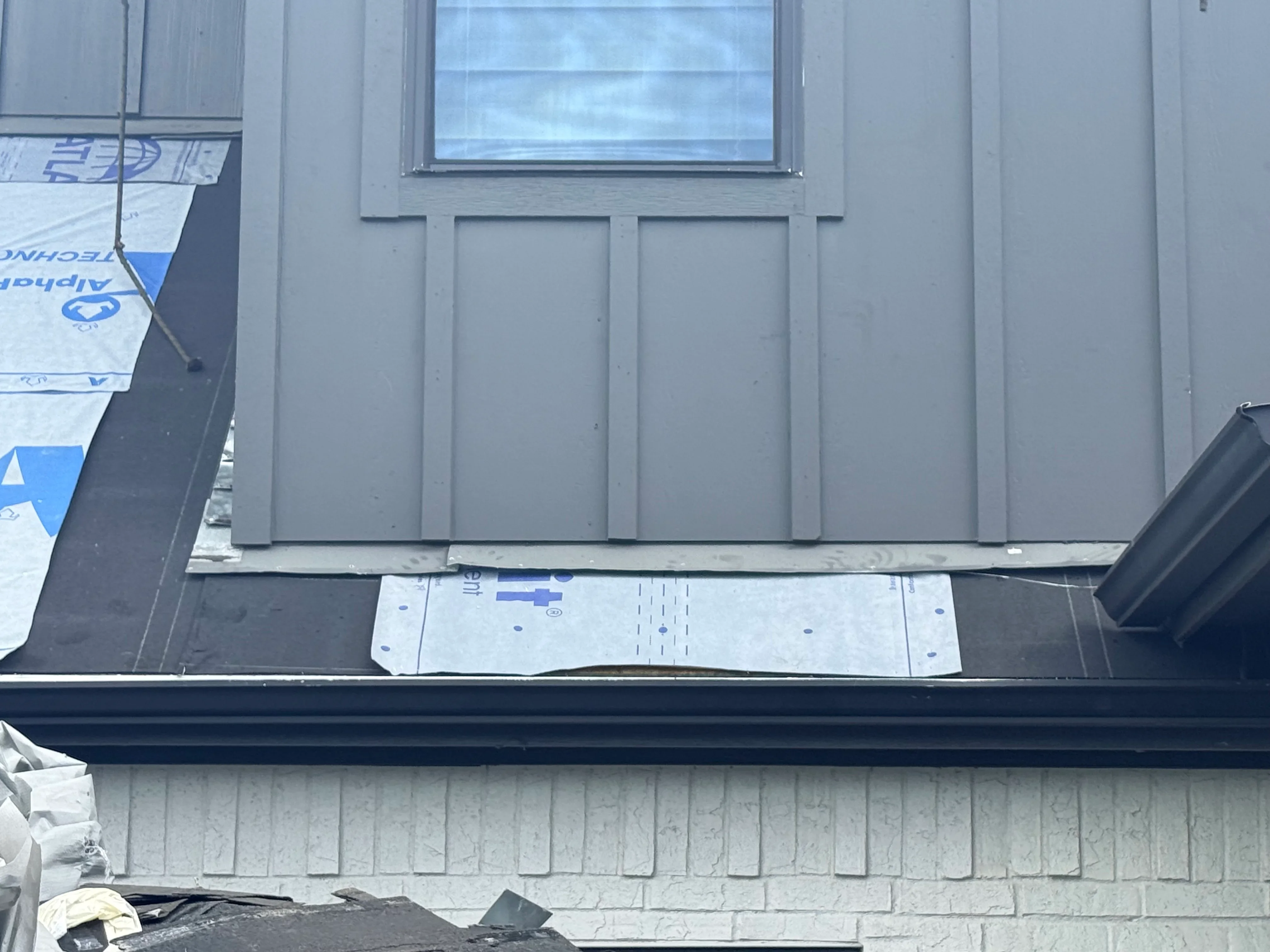 Roof sheathing with blue underlayment and window opening during installation