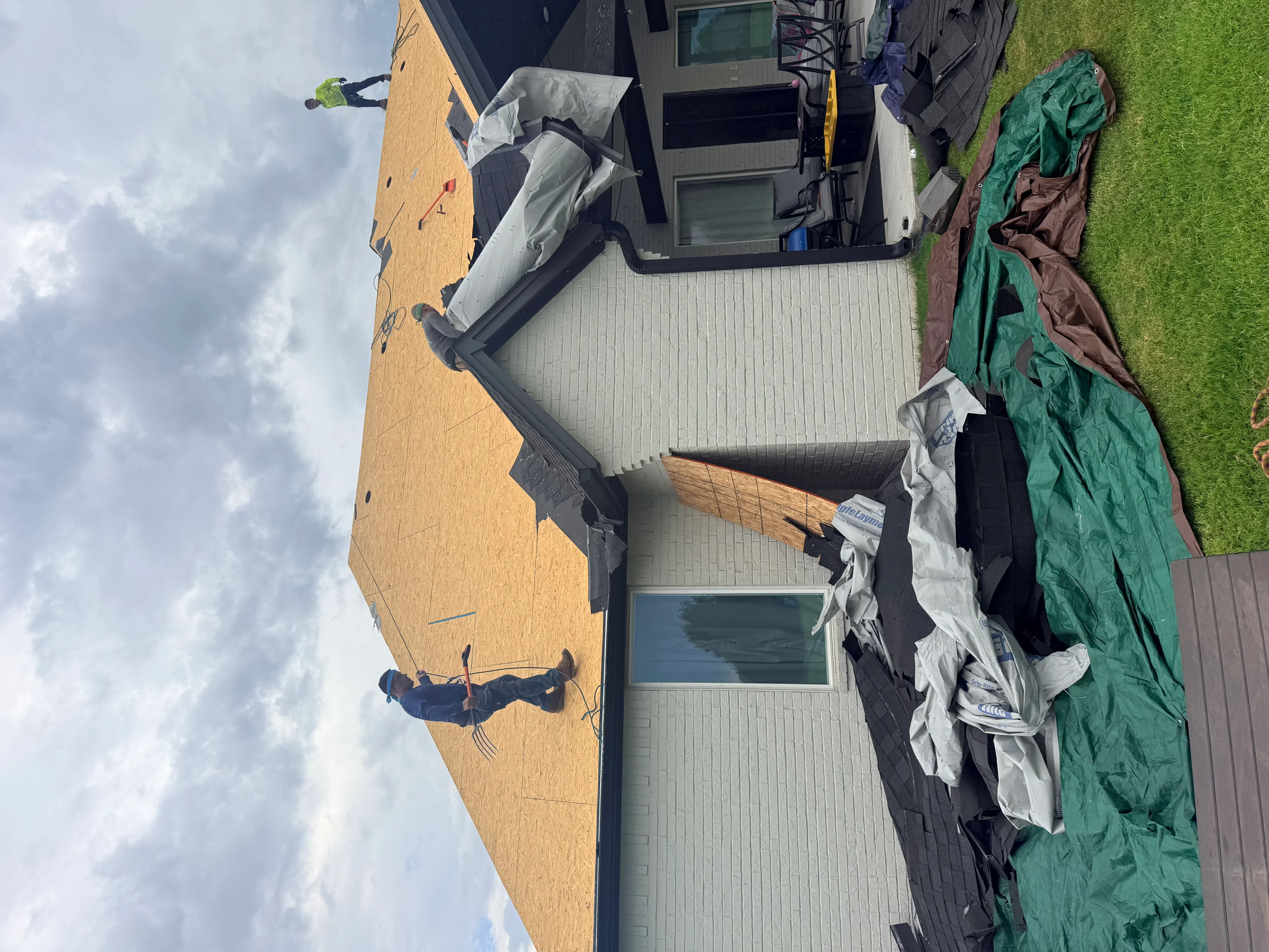 Residential roof replacement with corrugated metal roofing and protective tarps during installation