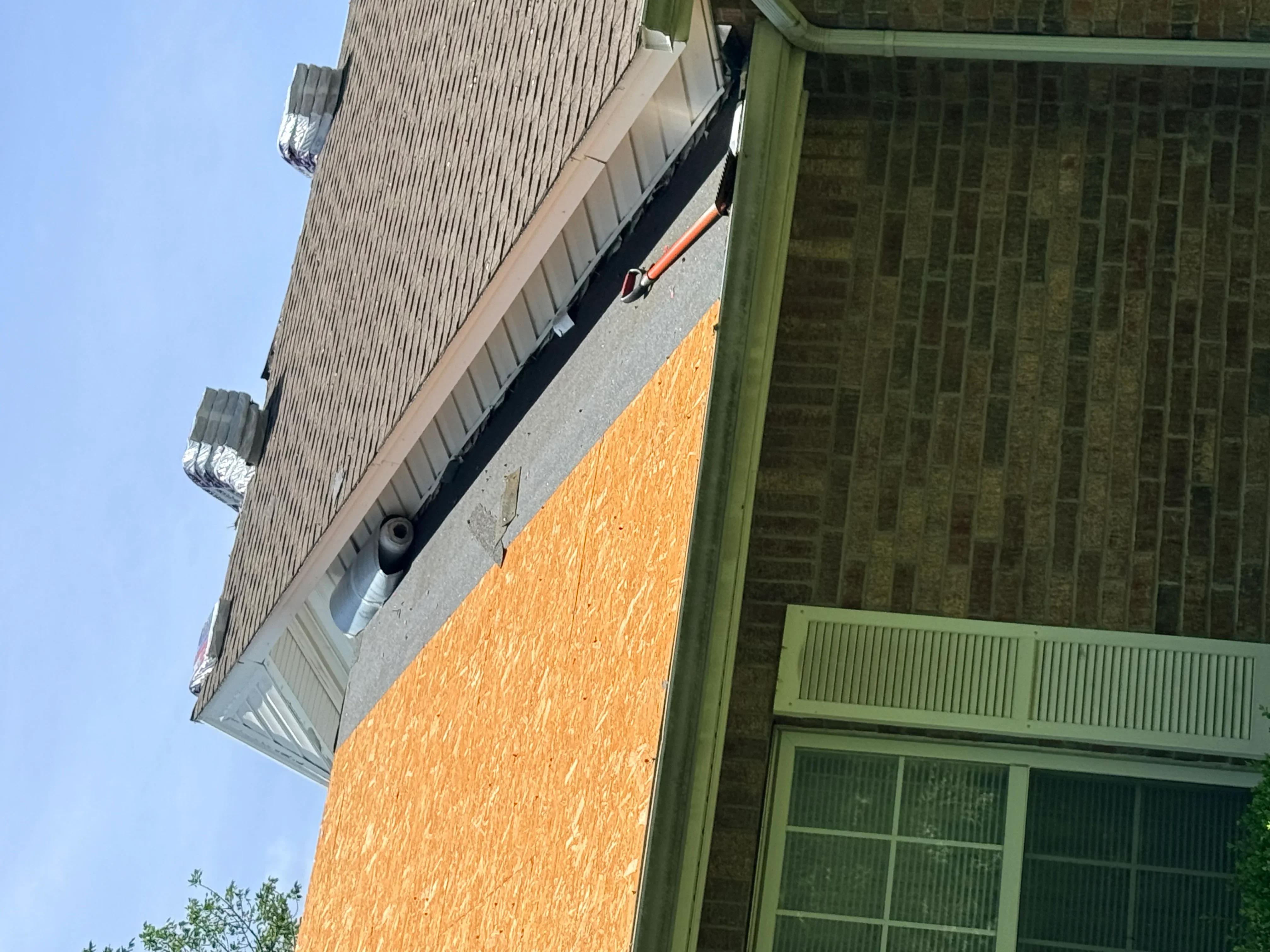 New corrugated metal roof with gutters and downspout on brick home