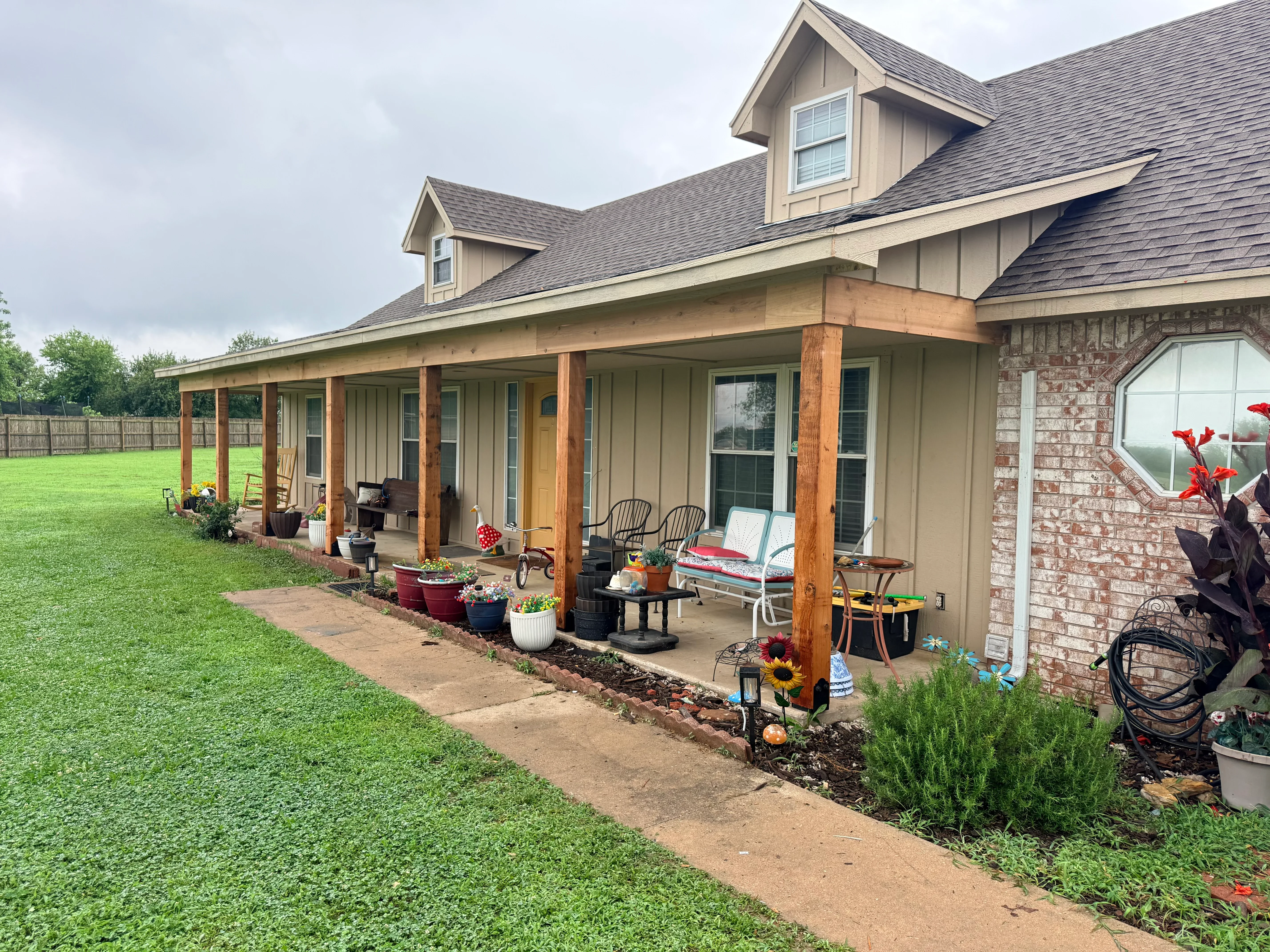 Gray architectural shingle roof with new soffit, fascia, and gutters on residential home with extended porch
